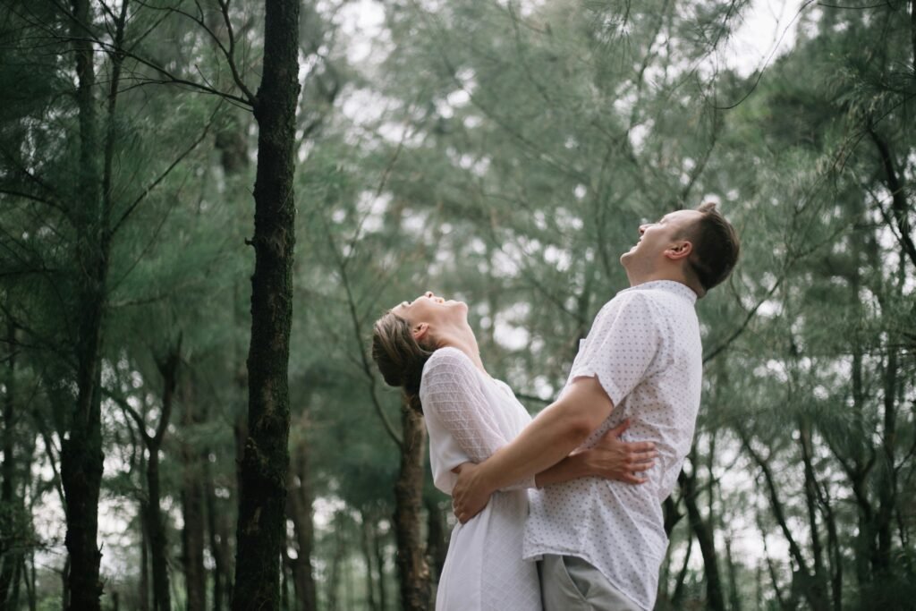a man and a woman standing in the woods a man and a woman standing in the woods